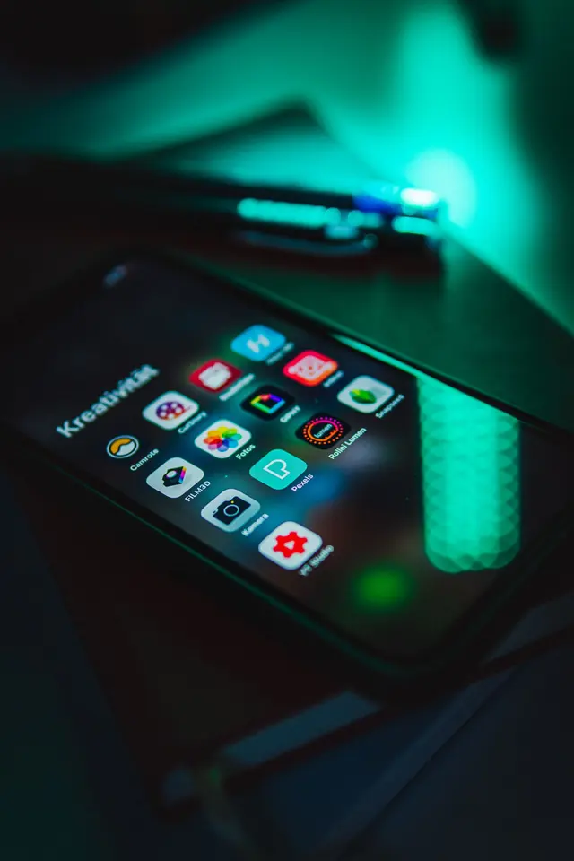 Smartphone real aceso em ambiente escuro com cores intensas